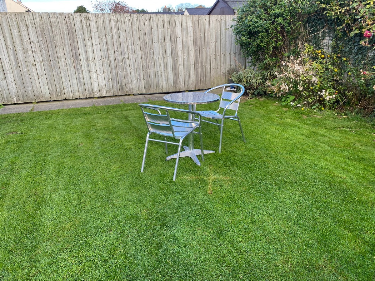 A high wooden fence enclosed the rear garden The back garden is enclosed by a high wooden fence