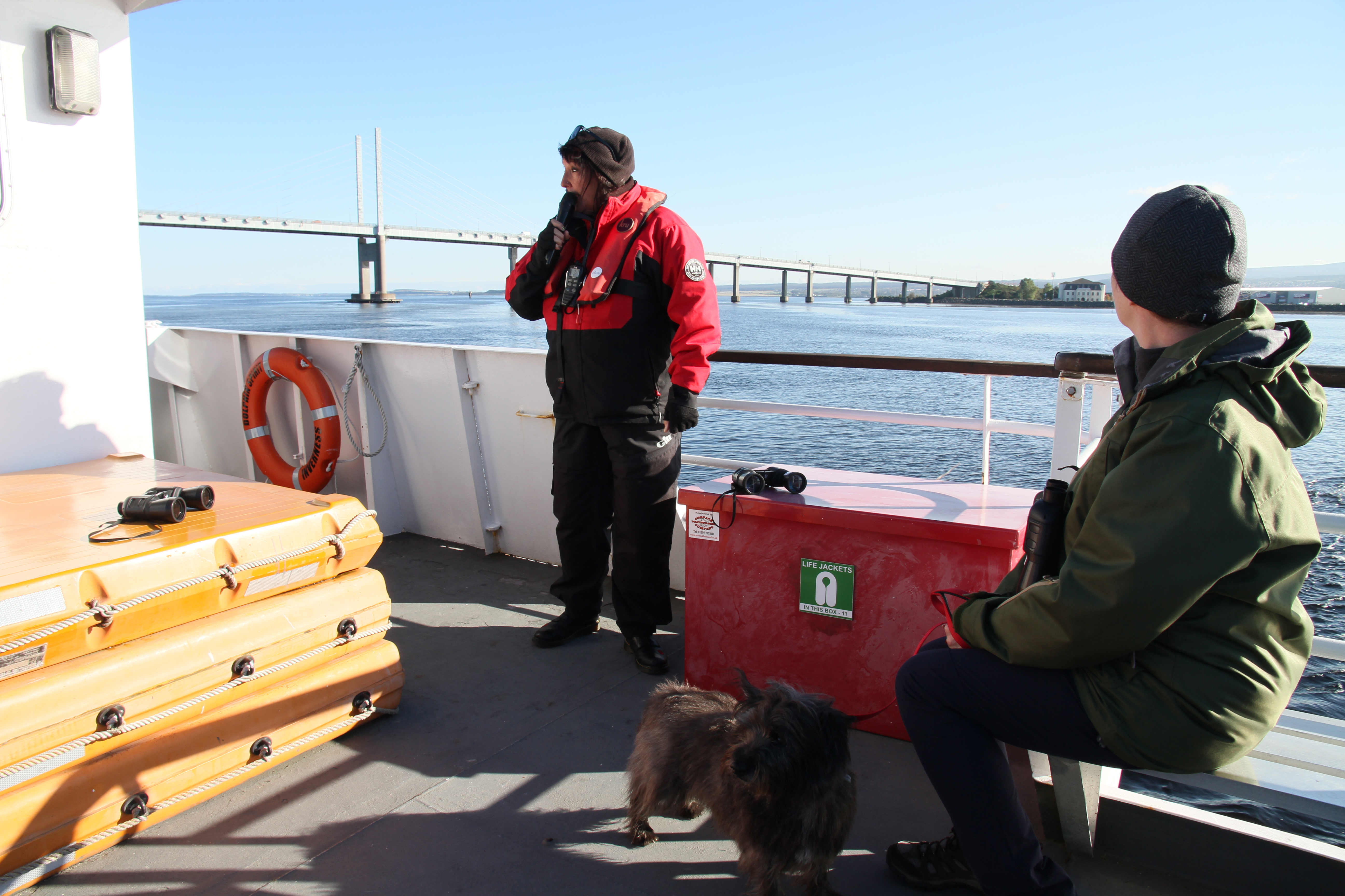 Hamish on a dog friendly dolphin spotting trip with Kessock Bridge in the background Some dolphin spotting boat trips are dog friendly